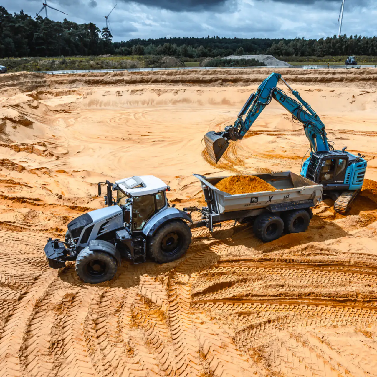 Bagger belädt einen Traktor mit Kippanhänger in der Sandgrube Haltern-Lavesum